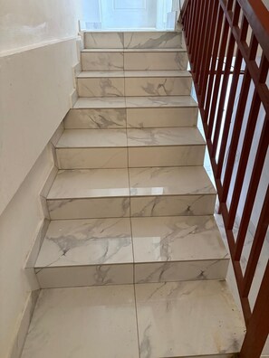 A staircase with marble steps and a wooden railing.