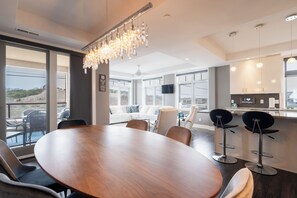 Une cuisine moderne dotée d’un grand îlot central, de tabourets de bar et d’un coin repas avec une table ronde et des chaises.