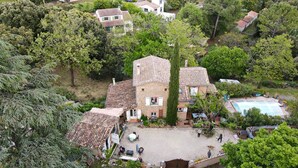 A residential area with a central building featuring a tiled roof, surrounded by trees and a swimming pool. - Maison piscine à Anduze (Anduze)