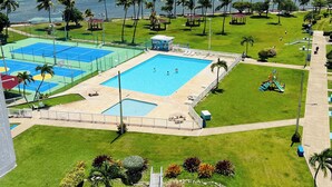 A swimming pool with a slide, surrounded by palm trees and a view of the ocean. - The Oasis - Private Island Getaway! (Fajardo)