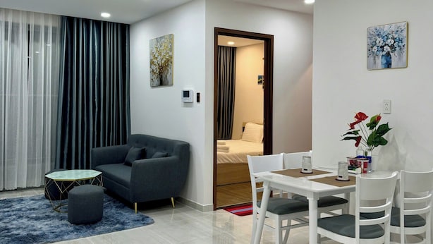 Una sala de estar moderna con un sofá, una mesa de centro y un comedor con una mesa y sillas.