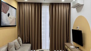 Una sala de estar moderna con sofá, una mesa de centro, televisor de pantalla plana y unidad de aire acondicionado.