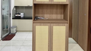 Una cocina moderna con armarios de madera, microondas integrado y una pequeña encimera.