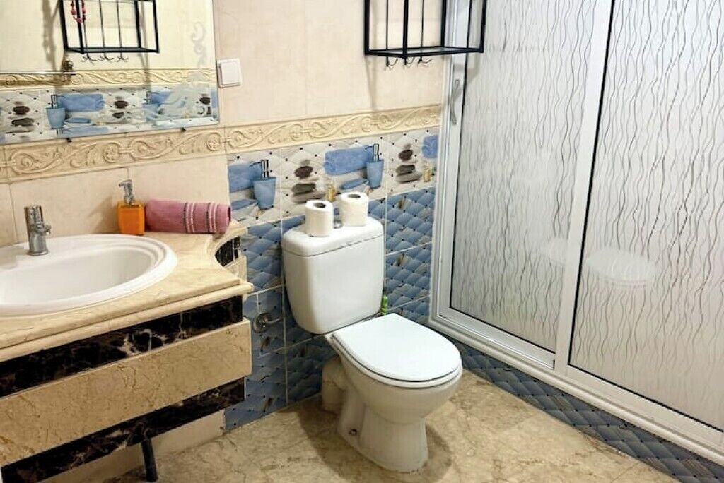 A bathroom with a sink, toilet, and shower.