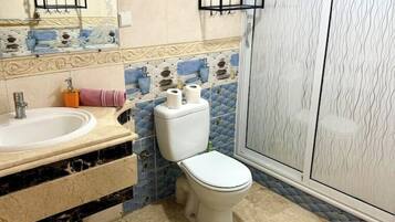 A bathroom with a sink, toilet, and shower.