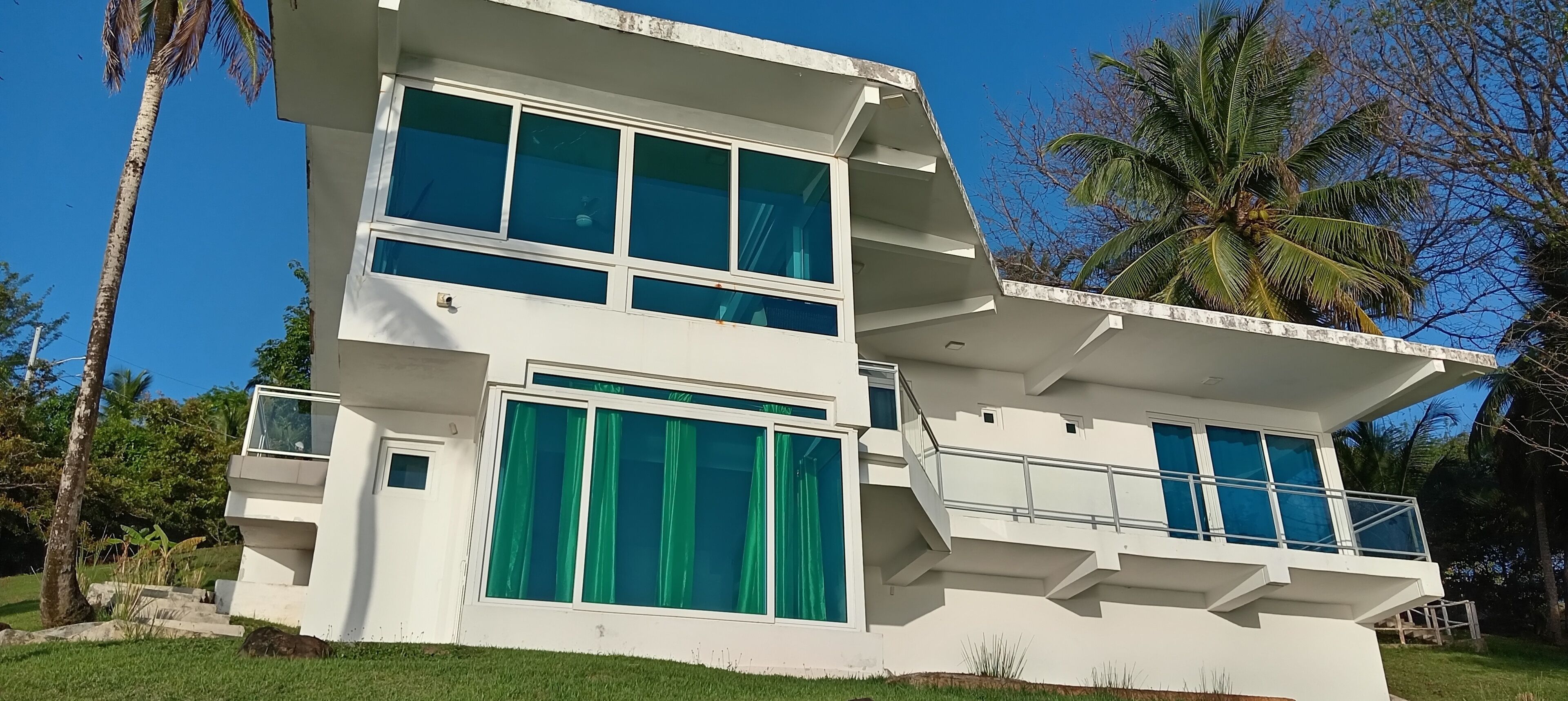 Un immeuble moderne à deux étages, doté de grandes fenêtres et d’un balcon.