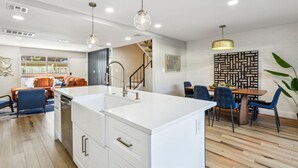 A modern kitchen with a central island, white cabinetry, and pendant lighting. - Old Town Scottsdale Condo | Pool | Patio | Grill (Scottsdale)