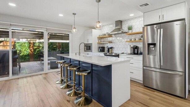 A modern kitchen with a large island, stainless steel appliances, and a view to a patio area. - Old Town Scottsdale Condo | Pool | Patio | Grill (Scottsdale)