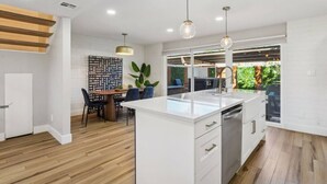 A modern kitchen with a central island, wooden flooring, and pendant lighting. - Old Town Scottsdale Condo | Pool | Patio | Grill (Scottsdale)