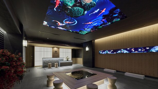 Eine moderne Hotelhalle mit Teich für Koi-Karpfen, Holzschemeln, einer Rezeption und einer großen Aquariumwand.