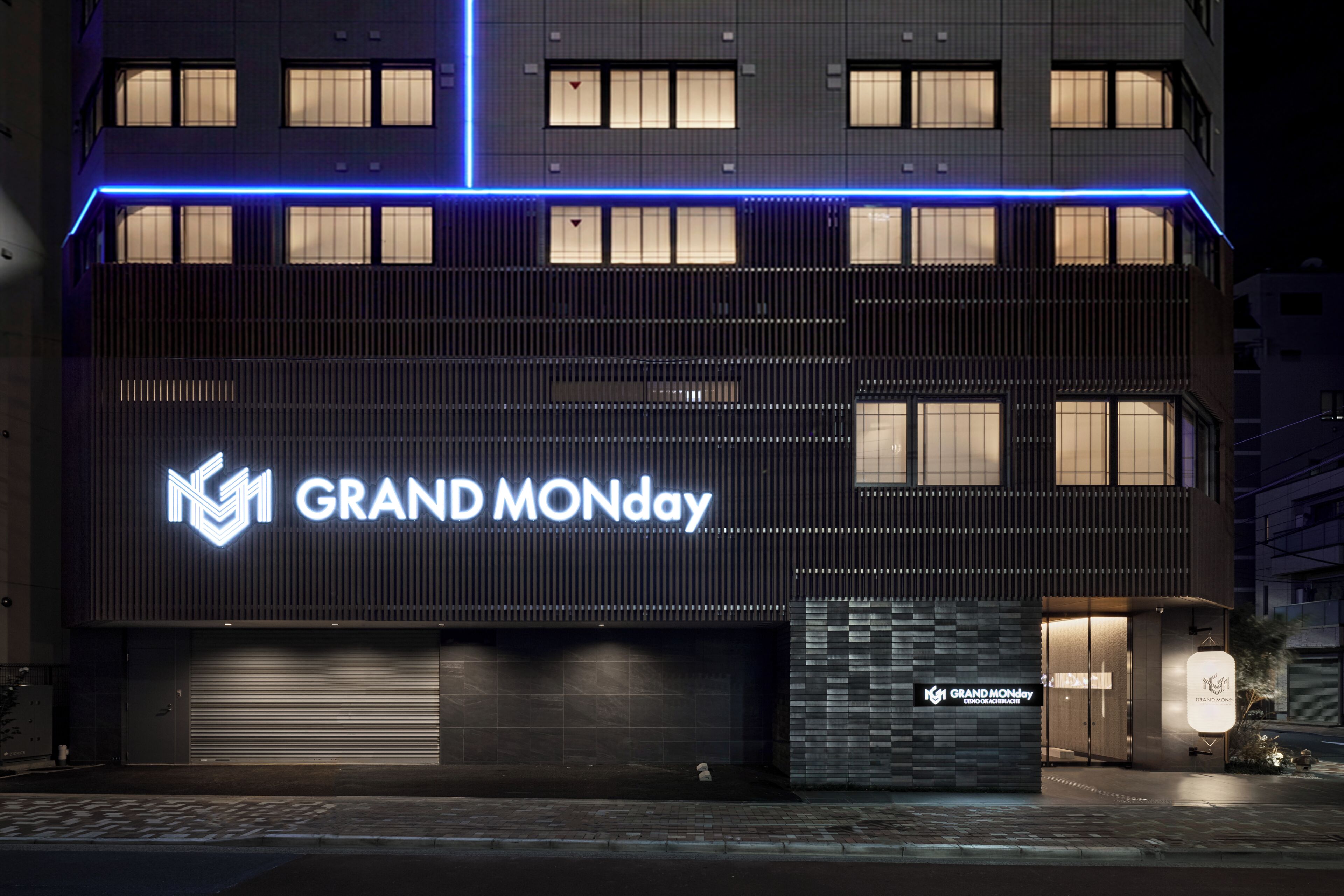 A modern building with a prominent 'GRAND MONDAY' sign, large windows, and a clean facade.