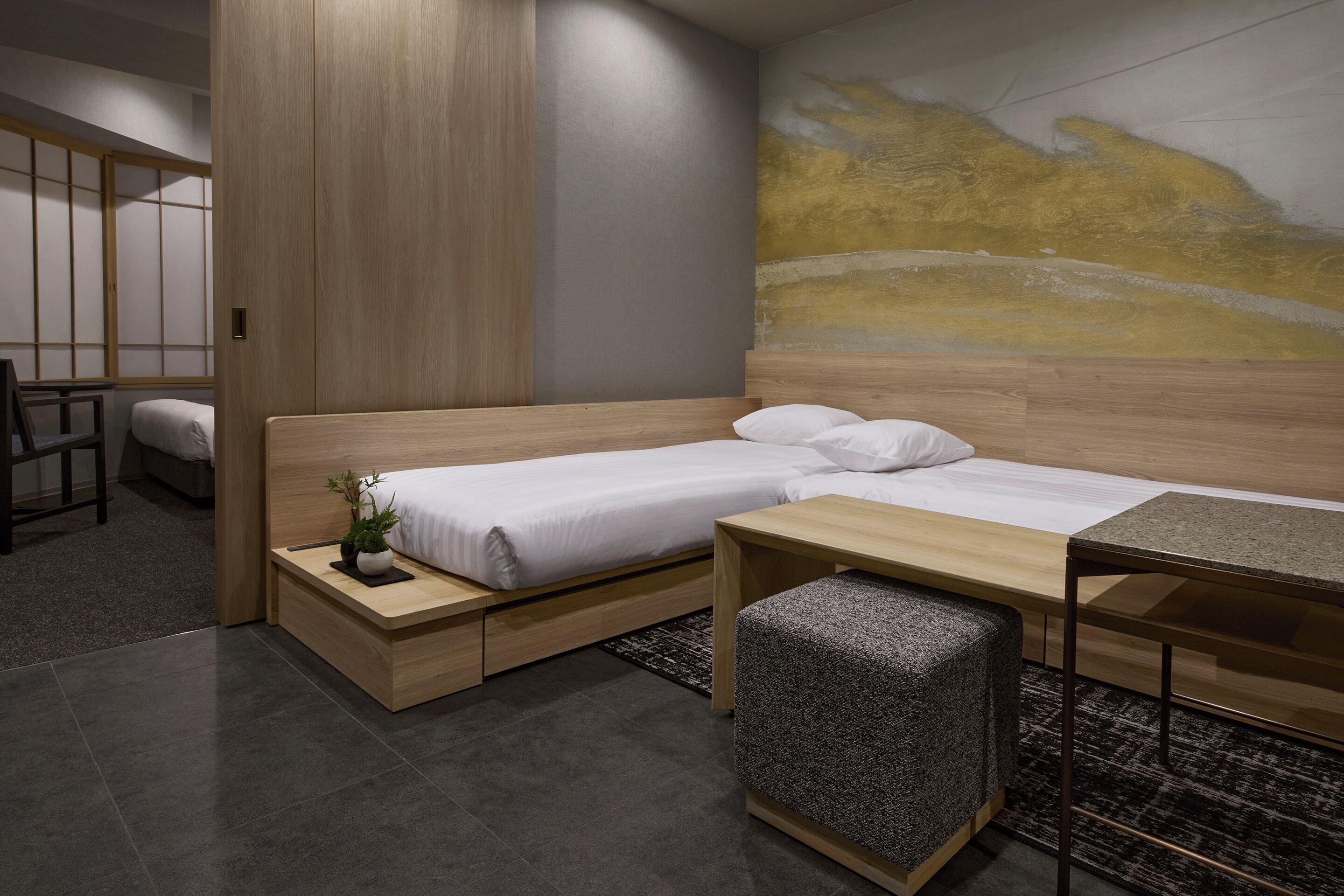 Ein modernes Schlafzimmer mit Bett, Nachttisch und einer kleinen Schreibtischzeile.