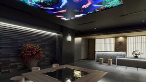 Ein modernes Interieur mit einer Rezeption, einem Wasserspiel und einer Deckeninstallation.