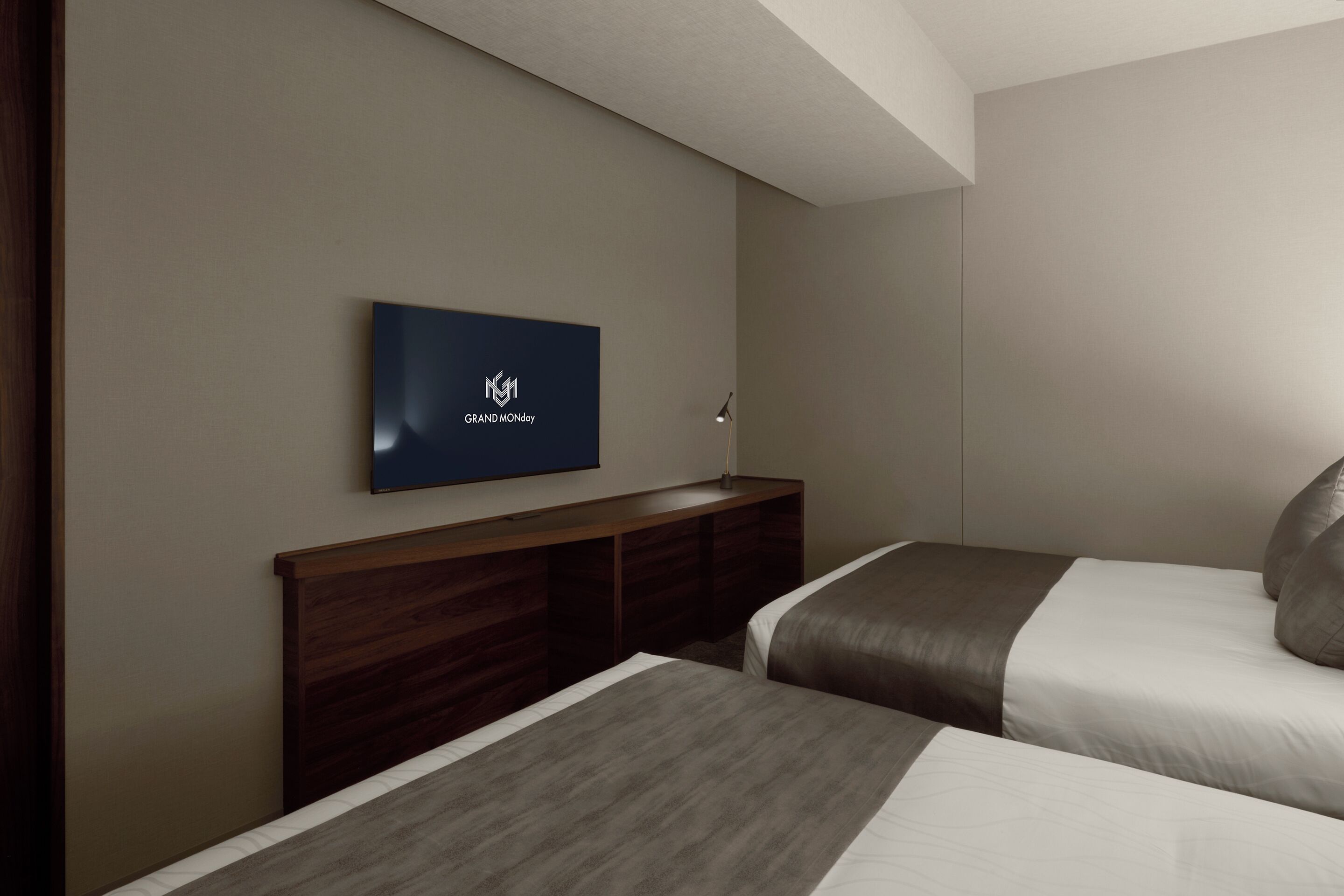A hotel room with two beds, a TV on the wall, and a wooden headboard.