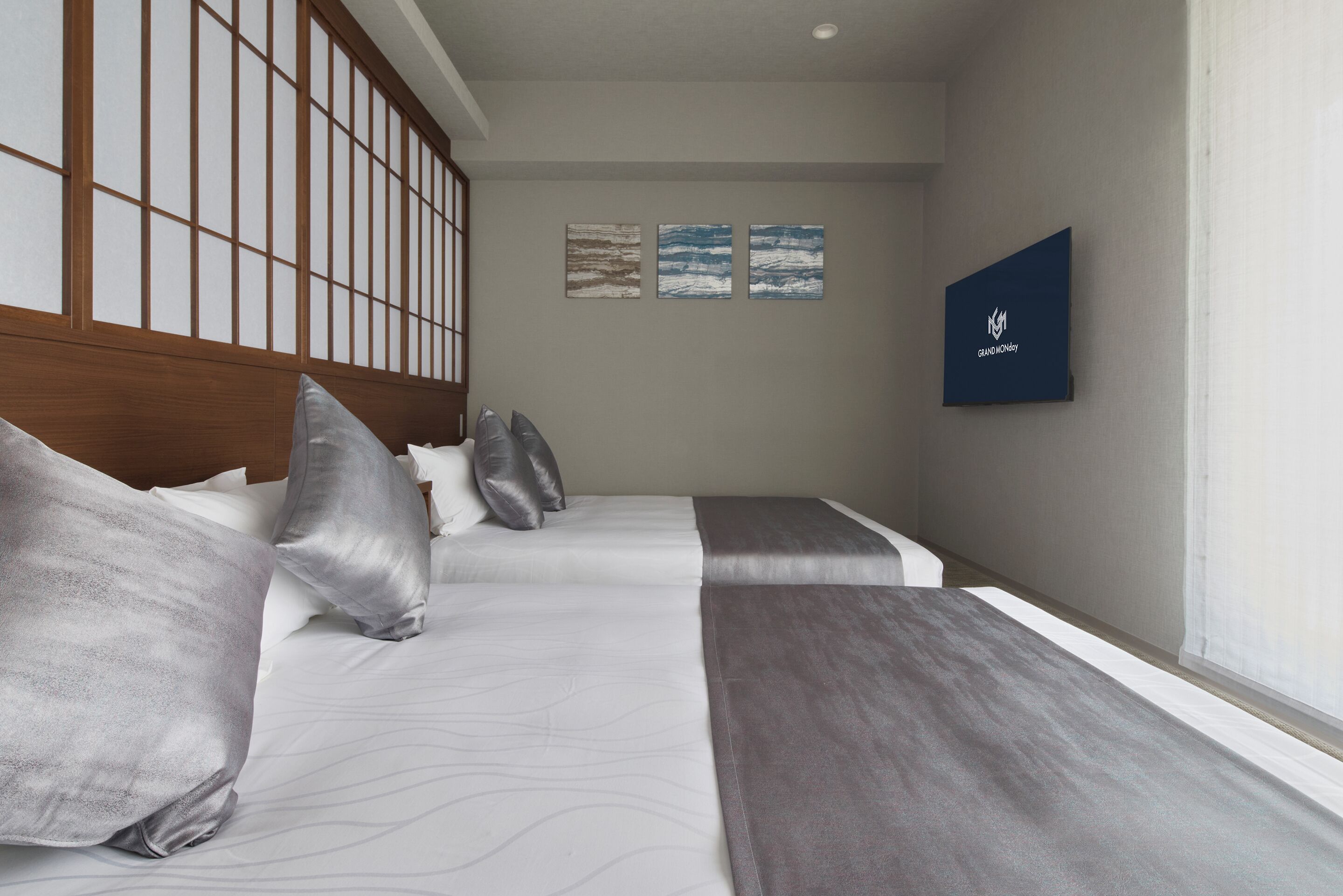 A hotel room with a large bed, a wooden headboard, and a wall-mounted TV.