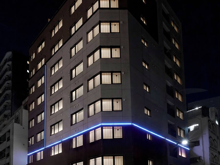 Ett hotell med flera våningar, upplyst skyltning och en framträdande entré.