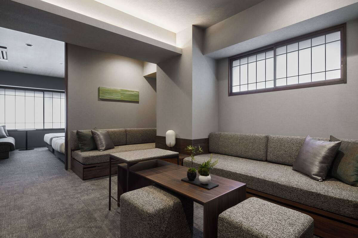 A modern living room with a sofa, a coffee table, and a small plant.