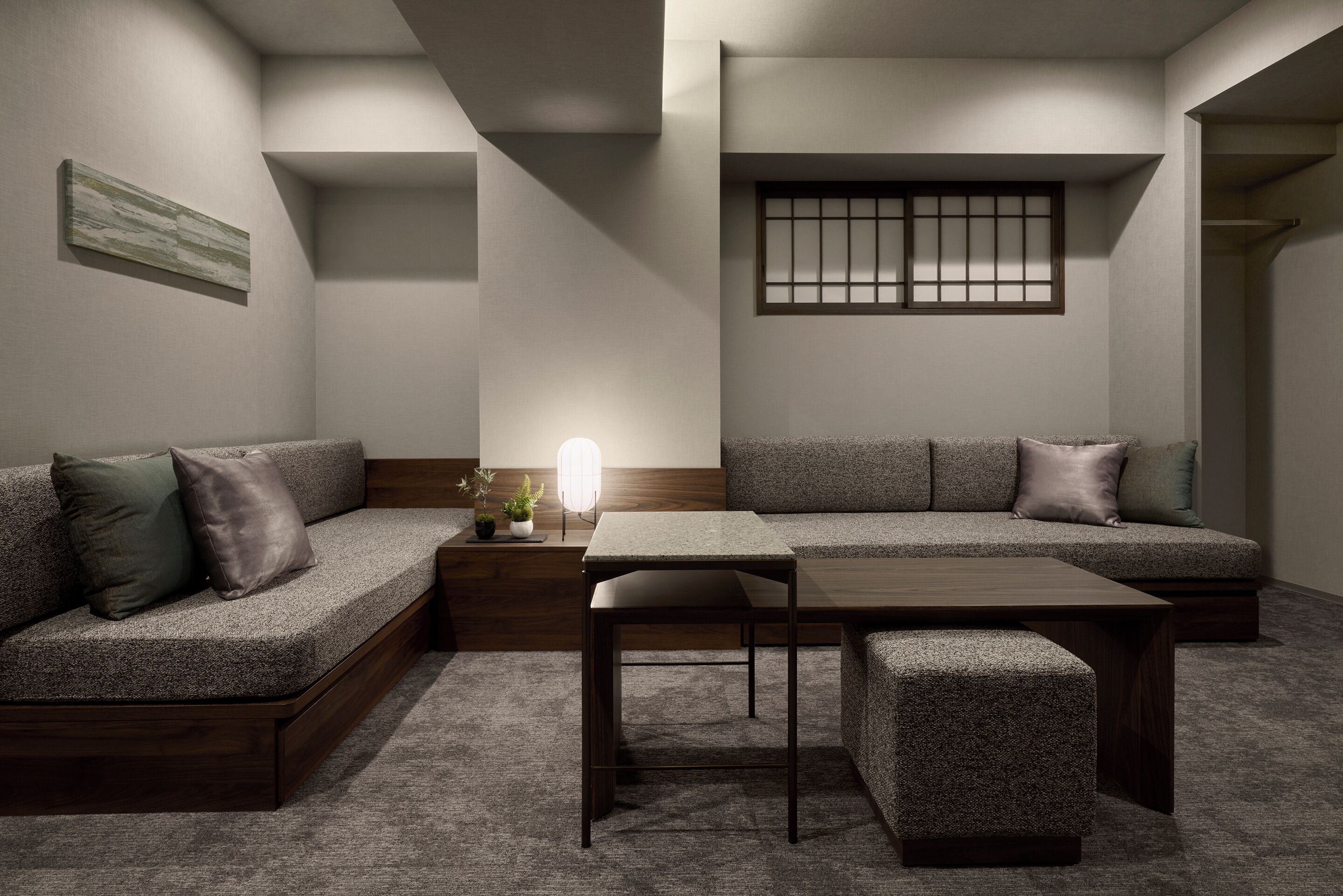 A modern living room with a sofa, a coffee table, and a small side table with a lamp.