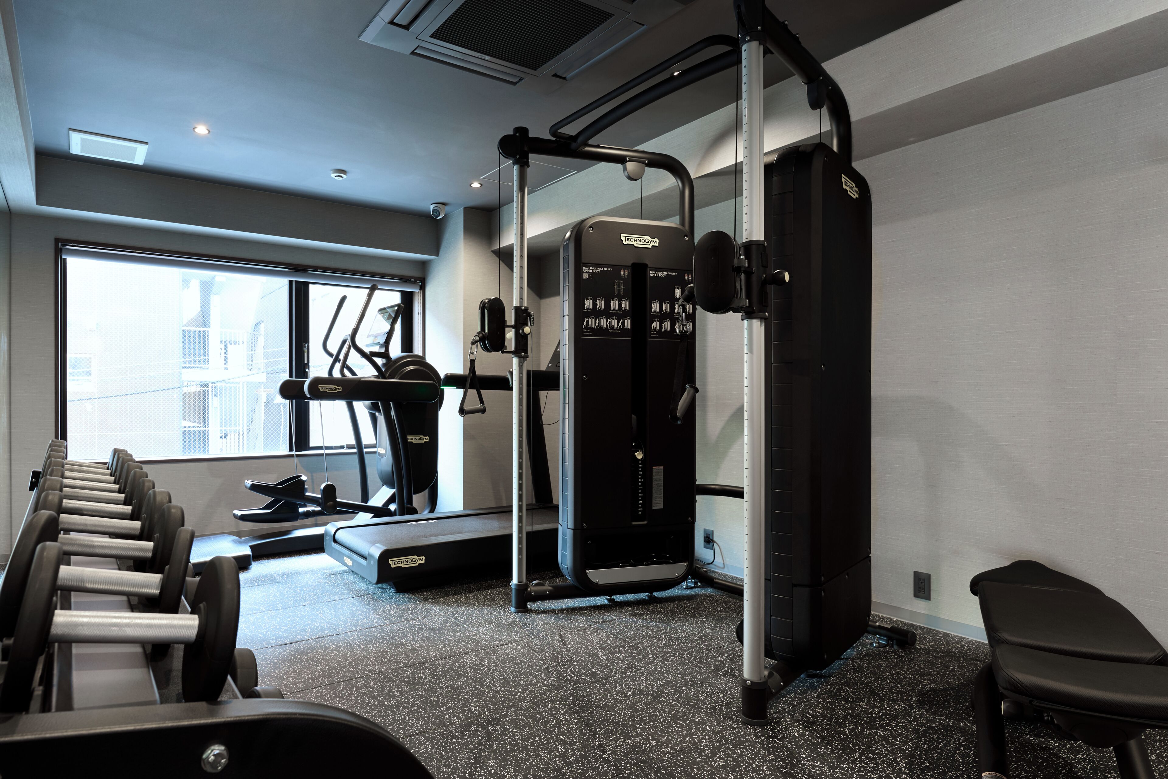 Ein Fitnessstudio mit Trainingsgeräten, Laufband und einem Fenster mit Blick.