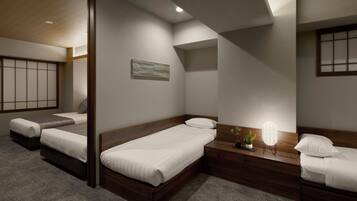 A hotel room with a large bed, a smaller bed, a bedside table with a lamp, and a window with a view.
