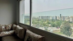 A room with a large window overlooking a residential area with buildings and greenery. - AR Apartments downtown (Wifi 200 Mb) (Fès)