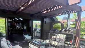 An outdoor patio with a grill, seating area, and a view of the backyard. - Niagara Retreat Center by Taiji Qi Yoga (niagara Falls)