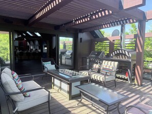 Eine Terrass mit Grill, Sitzgelegenheit und Blick auf den Garten.