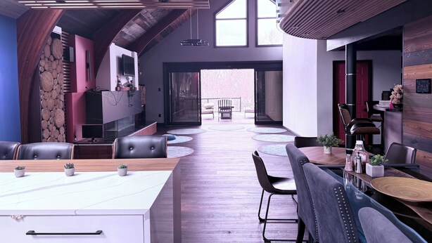 A spacious interior with high ceilings, a wooden ceiling, a large dining area, and a view to an outdoor patio. - Niagara Retreat Center by Taiji Qi Yoga (niagara Falls)