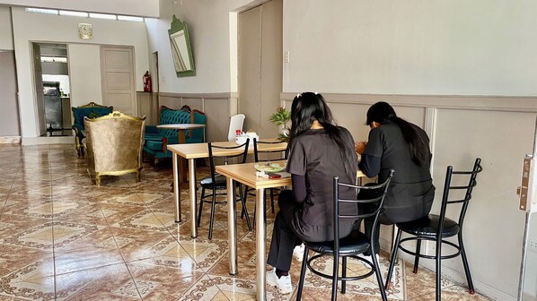 A dining area with a table and chairs, a clock on the wall, and a door leading to a kitchen. - Elegant room 2 blocks from the Plaza de Armas of Cusco (Cusco)