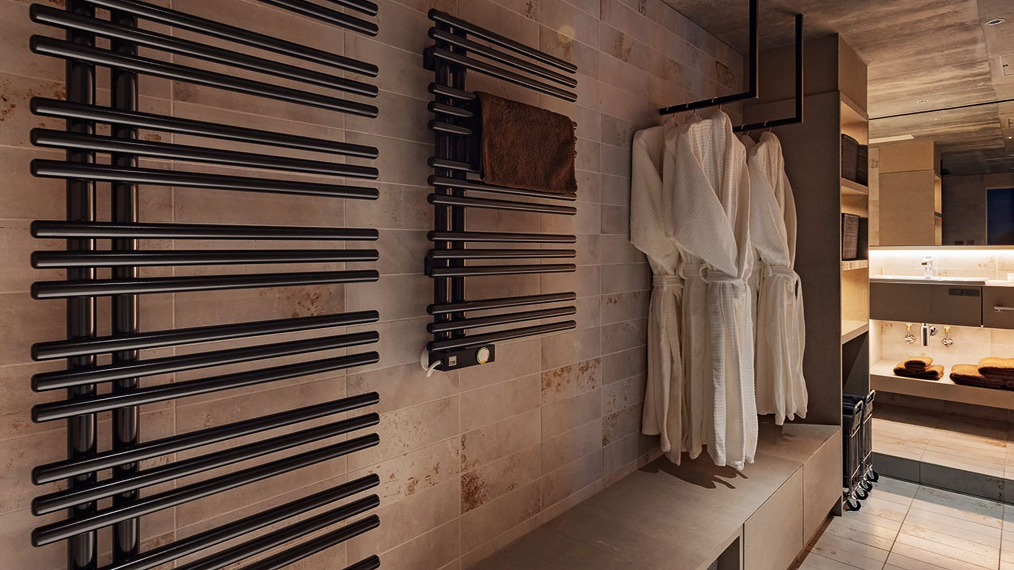 A modern bathroom with a towel rack, a mirror, and a bench.