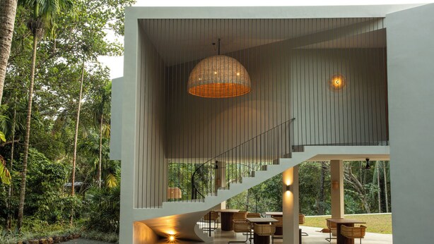 A modern interior with a staircase leading to a balcony, surrounded by lush greenery. - The Sevana (Matara)