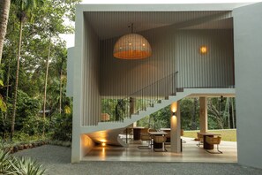 A modern interior with a staircase leading to a balcony, surrounded by lush greenery. - The Sevana (Matara)