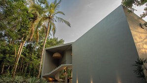 A modern building with a unique architectural design, featuring a prominent staircase and a well-lit interior. - The Sevana (Matara)