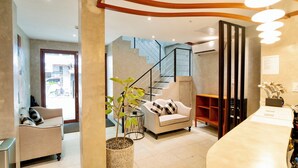 Ein modernes Interieur mit Treppe, Sofa, Couchtisch und einer Pflanze.
