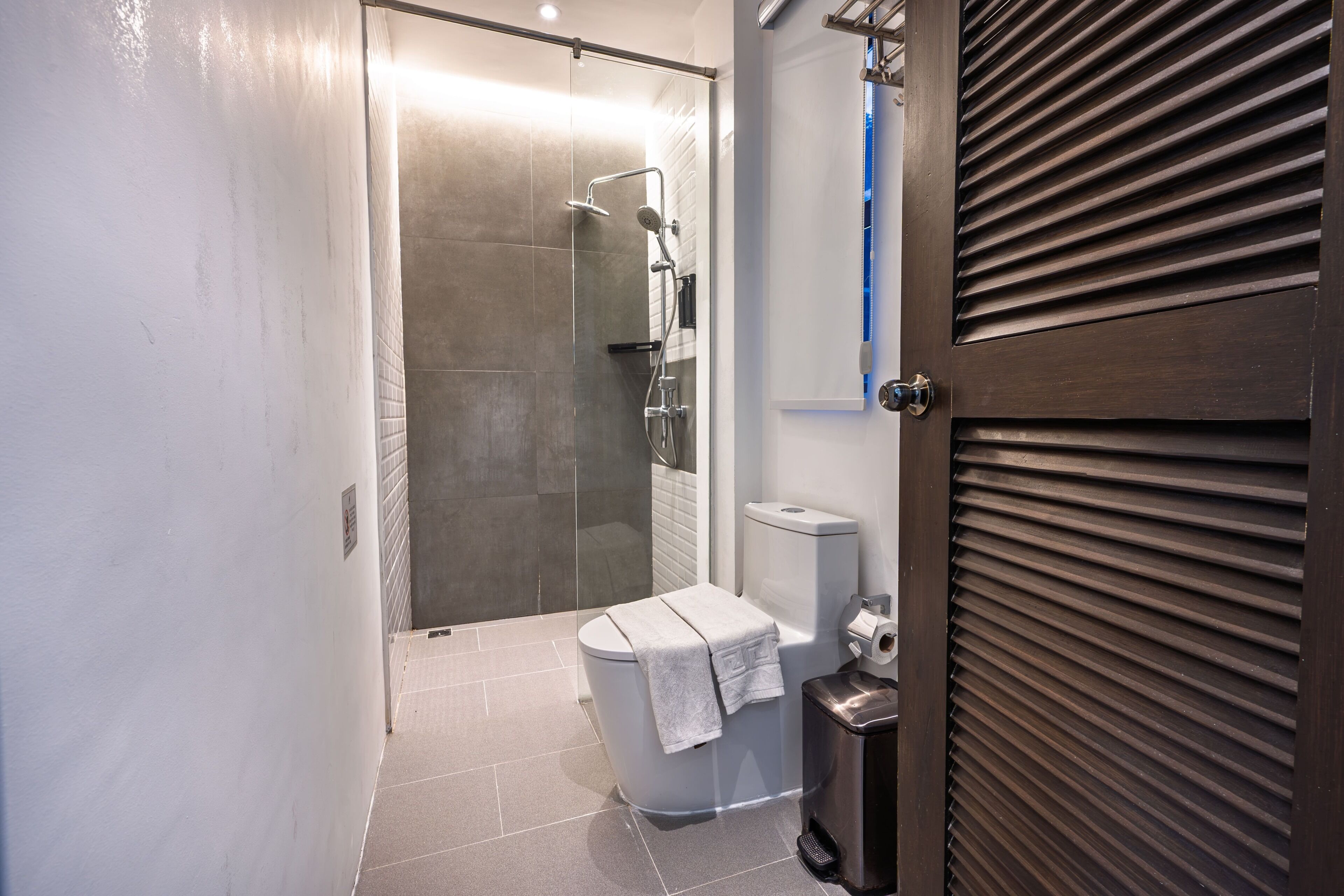 Un bagno con doccia, wc e cestino.