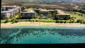 A coastal resort with multiple buildings, a beach, and clear turquoise waters. - Beautiful full resort access -2-bedroom condo with AC in delightful Lahaina (Lahaina)