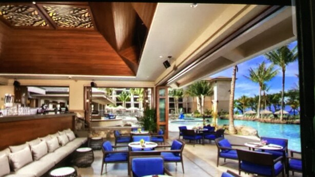A modern outdoor lounge area with blue seating, a pool, and a bar. - Beautiful full resort access -2-bedroom condo with AC in delightful Lahaina (Lahaina)