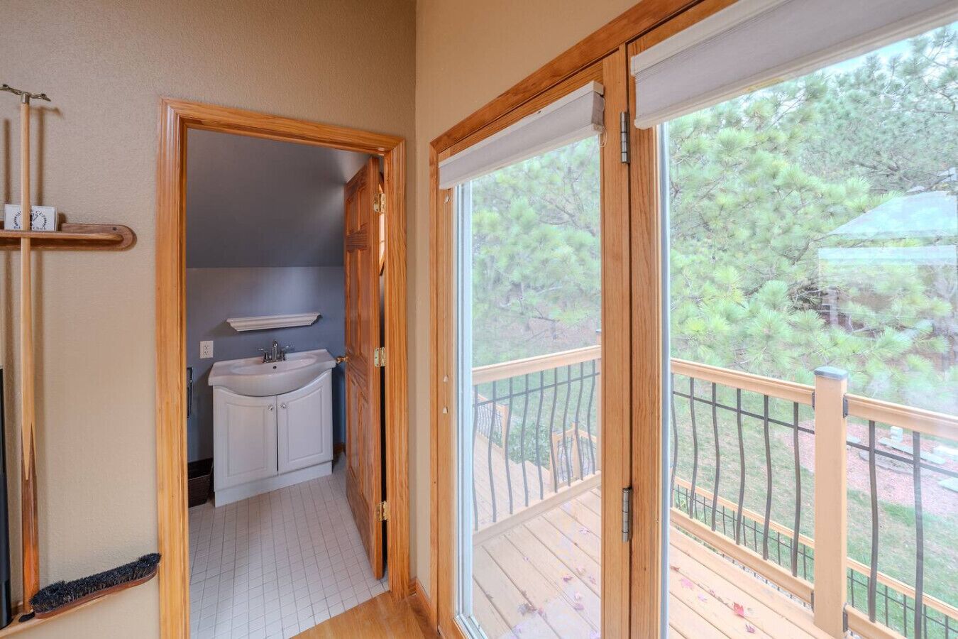Una puerta de madera que da a un baño con lavamanos y armarios.