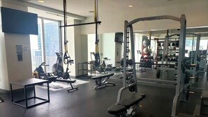 Una palestra con diverse attrezzature per l'allenamento, tra cui tapis roulant, cyclette e macchinari per pesi.