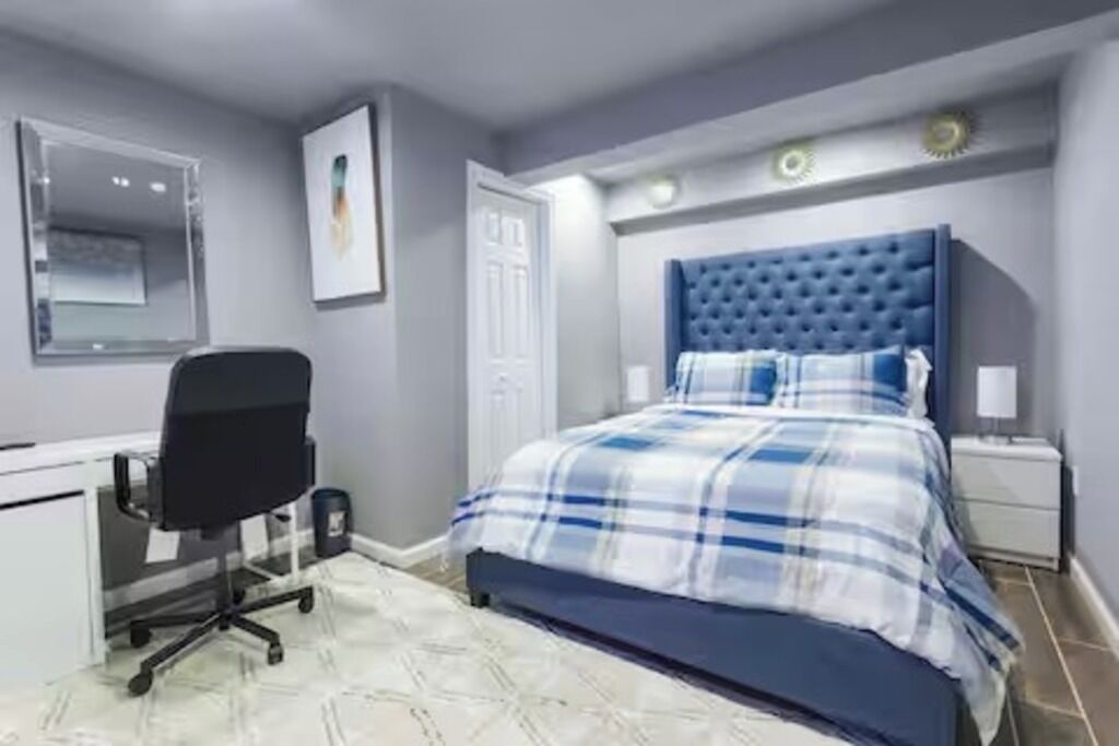 Een slaapkamer met een bed, een bureau en een stoel.