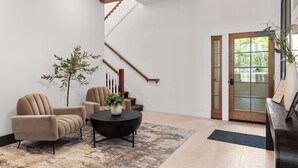 A modern lobby with a staircase, a reception desk, and a seating area with a coffee table. - Huge King Suite w. Rain Shower, Balcony, Wet Bar (Beaufort)
