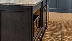 A kitchen with a marble countertop, dark panel walls, and a patterned floor. - Huge King Suite w. Rain Shower, Balcony, Wet Bar (Beaufort)