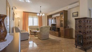 A spacious living room with a chandelier, leather armchairs, a coffee table, and a television. - Holiday apartment mit Terrasse und Klimaanlage (Pula)