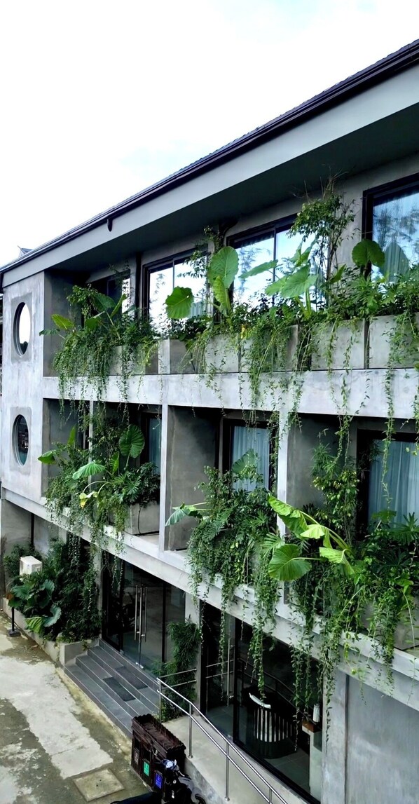 A modern building with multiple balconies covered in greenery. - Z Garden Hotel Managed by H Hospitality (El Nido)
