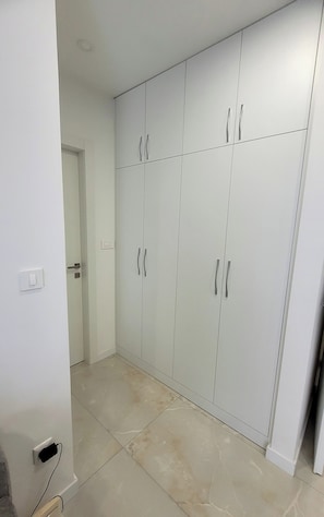A hallway with a large white wardrobe, a door, and a light switch on the wall. - Charming apt with balcony in the heart of Split (Split)