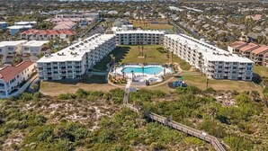 Resort com piscina central, vários edifícios e paisagem natural ao redor.