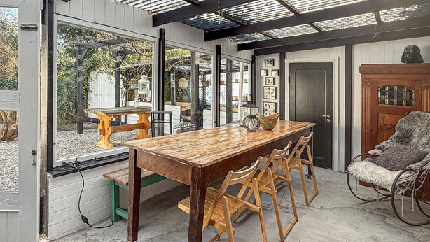 A dining area with a wooden table and chairs, a bench, and a view through large windows. - Lovely home in Nørreballe with WiFi (Nørreballe)