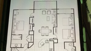 Un plan d’étage d’une chambre d’hôtel comprenant un coin cuisine, un espace repas, une salle de bain et un coin salon.