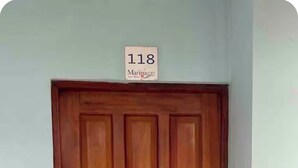Een houten deur met een huisnummer erboven.