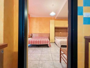 Una stanza con un letto, una sedia e un armadio.
